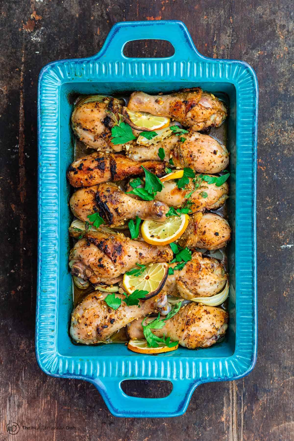 Baked chicken drumsticks with lemon and garlic. Parsley garnish