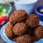 Falafel serviert in einer Schüssel mit Beilagensalat, Tahini und Fladenbrot