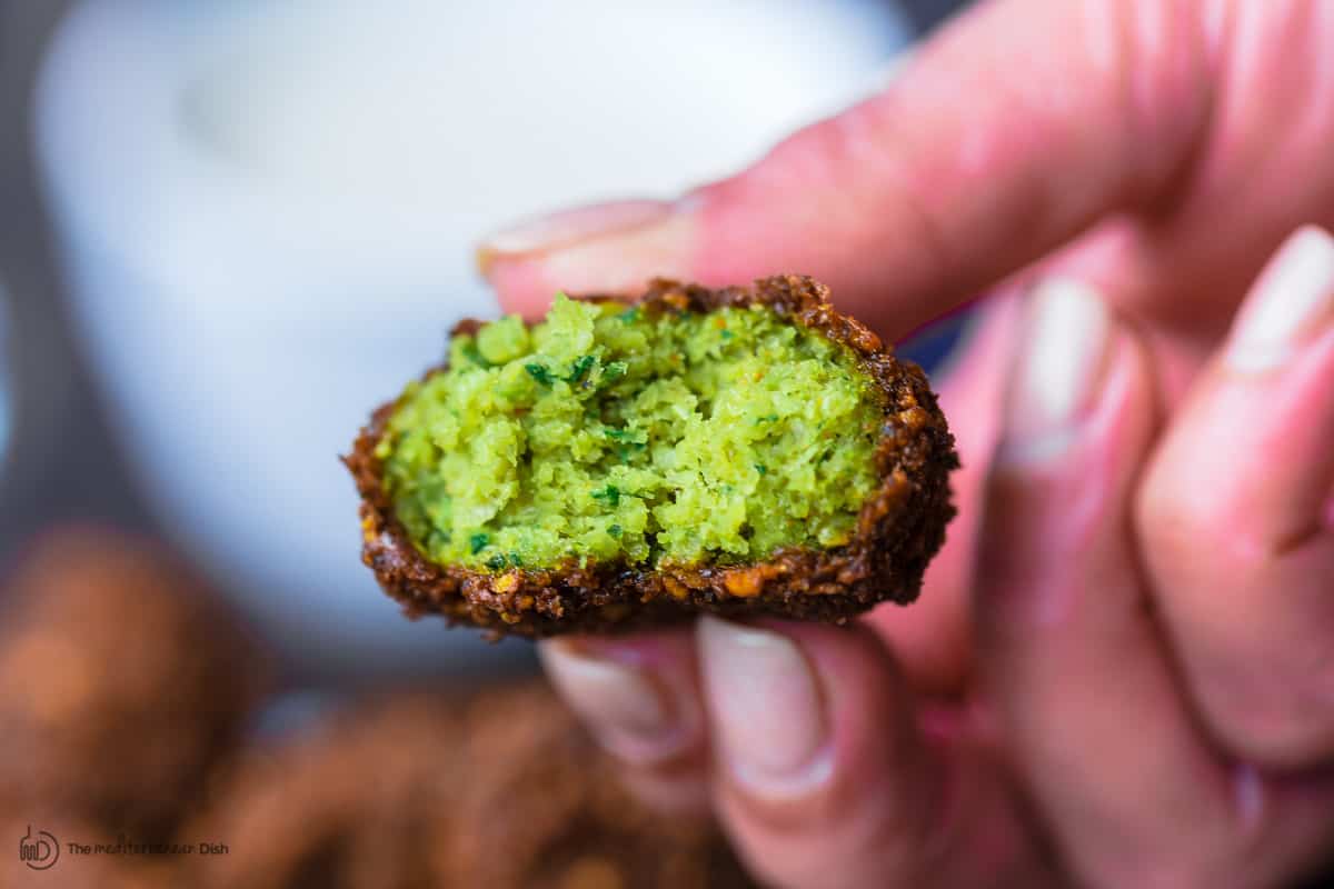 One falafel cut to reveal a green middle 