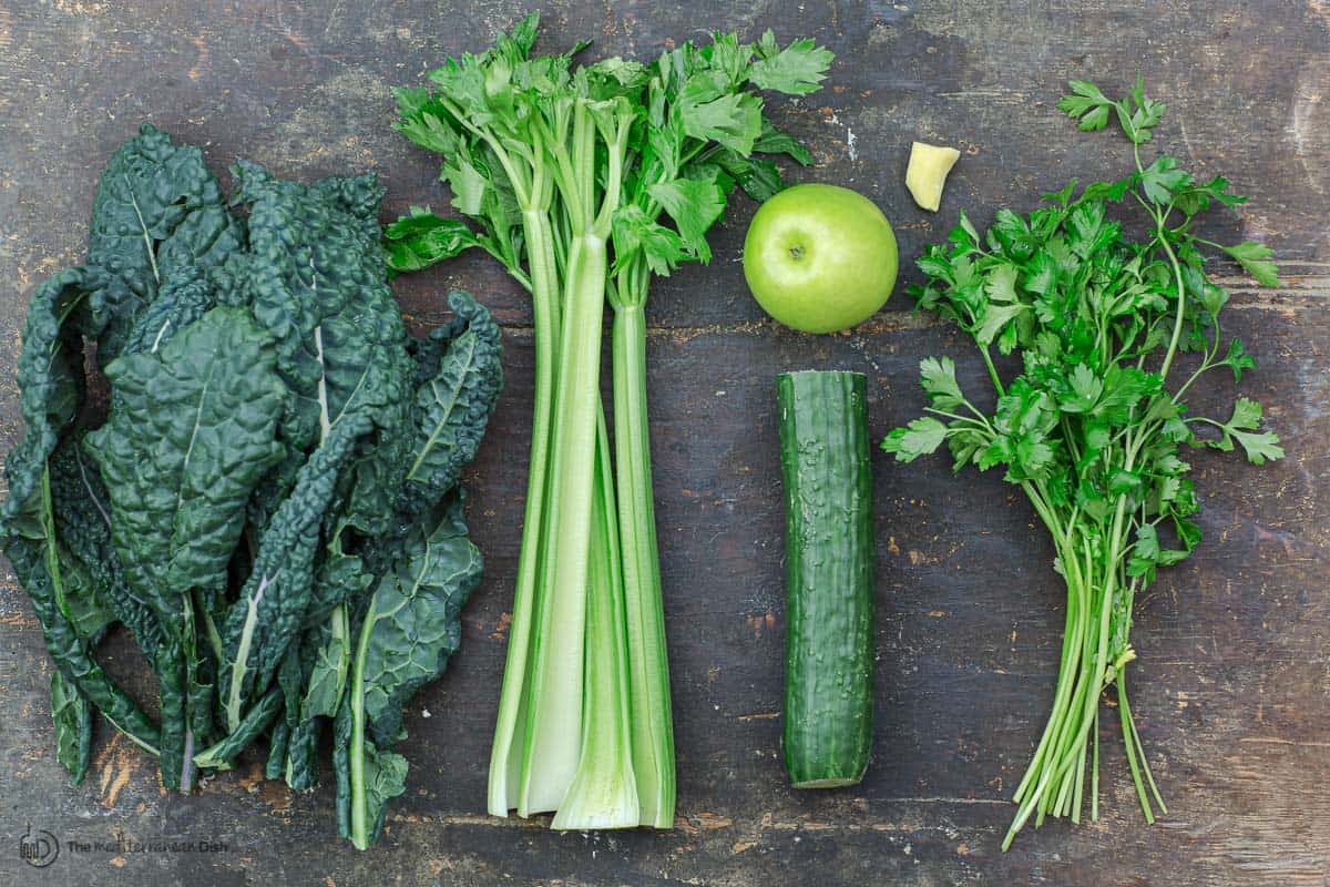 Ingredients for green juice. kale, celery, apple, ginger, cucumber, and parsley