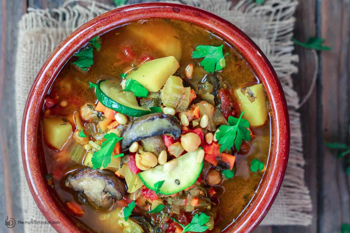 Vegetable soup with mushrooms and zucchini in clay bowl