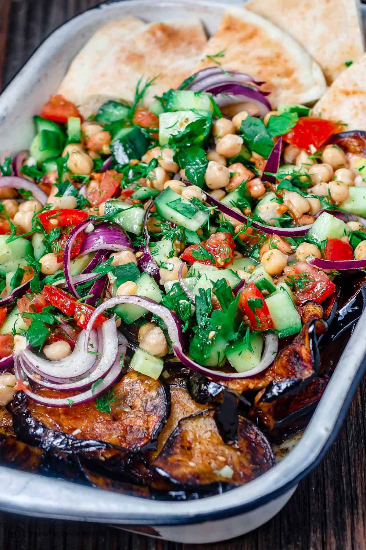 Mediterranean chickpea salad with a side of eggplant and pita