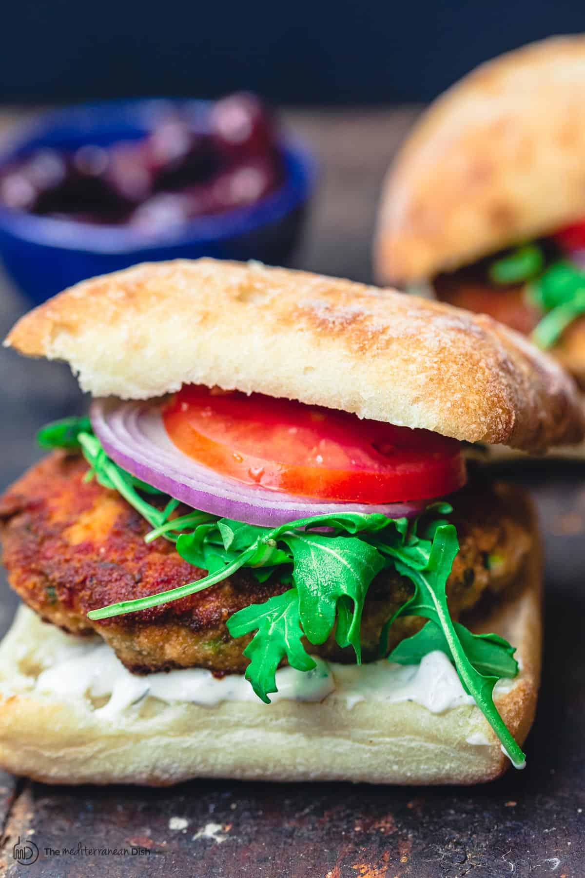 Juicy salmon burgers, served in Italian ciabatta rolls with arugula, tomatoes, and sliced onions