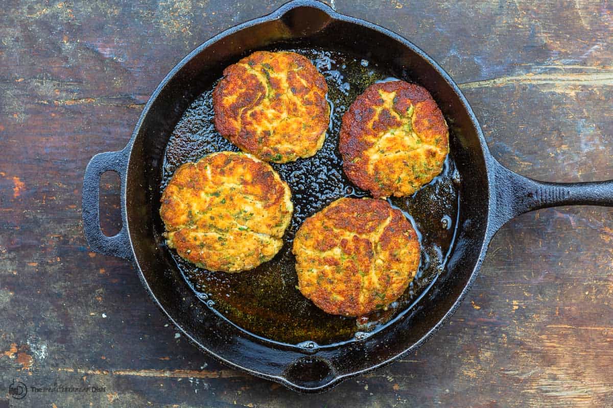 Cooked salmon burgers in skillet