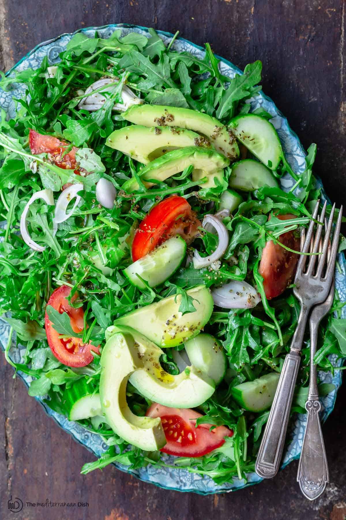 Arugula salad on platter with two forks