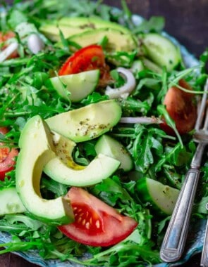 Arugula salad with avocado, cucumber, tomatoes and shallots