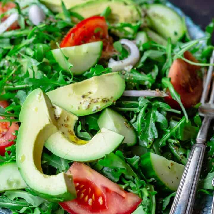 Arugula salad with avocado, cucumber, tomatoes and shallots