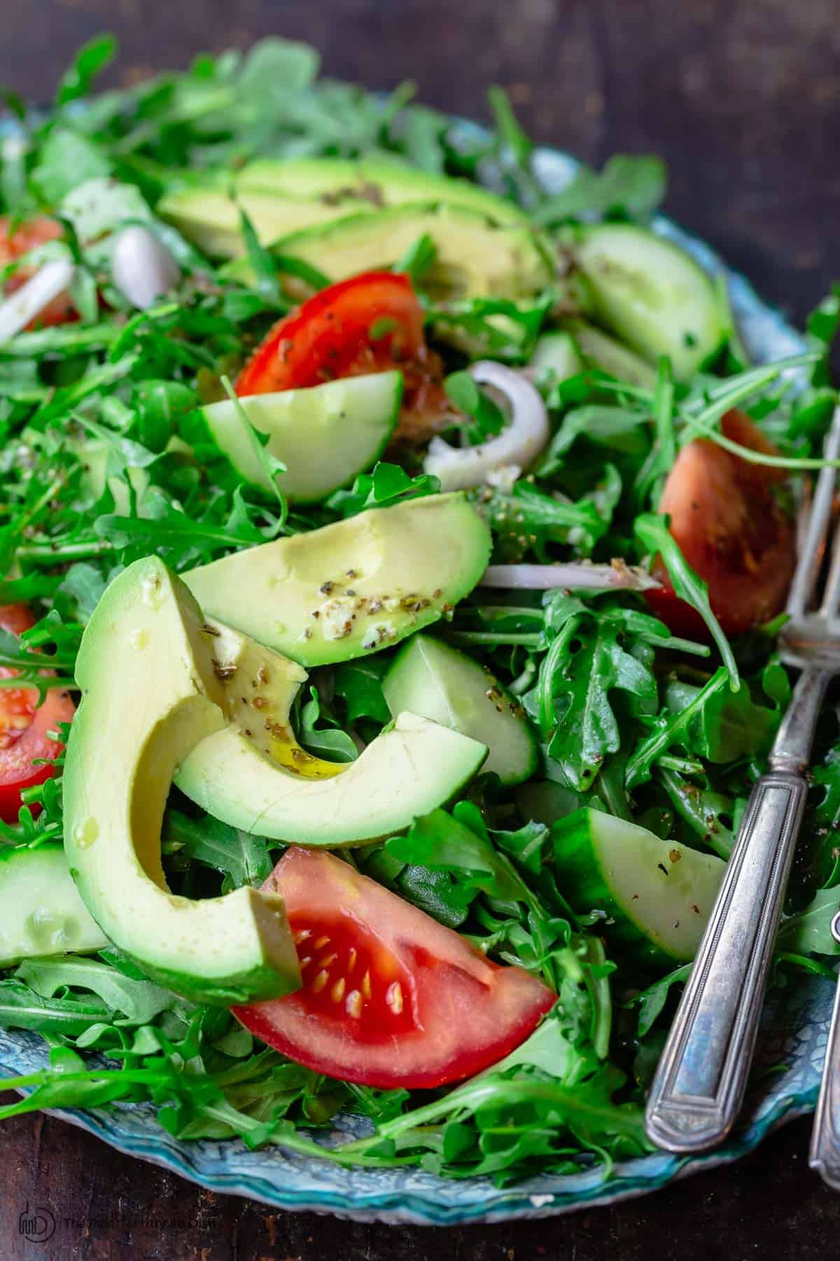 Arugula salad with avocado, cucumber, tomatoes and shallots