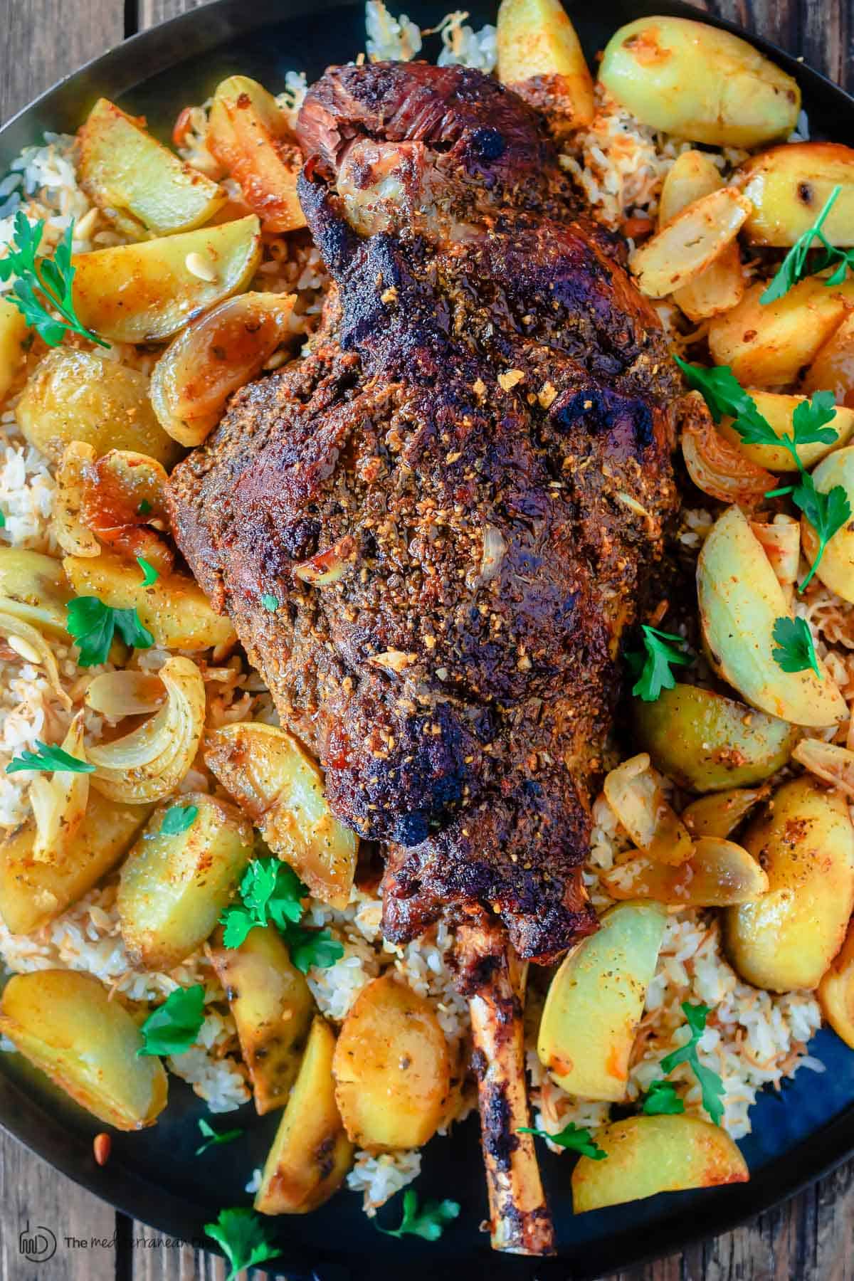 Roasted leg of lamb with potatoes over a bed of rice