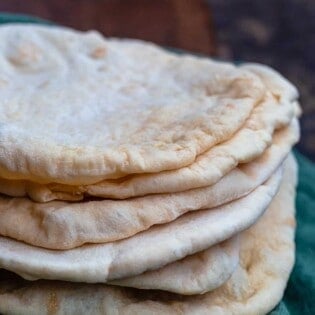 Stack of pita bread over a kitchen towel