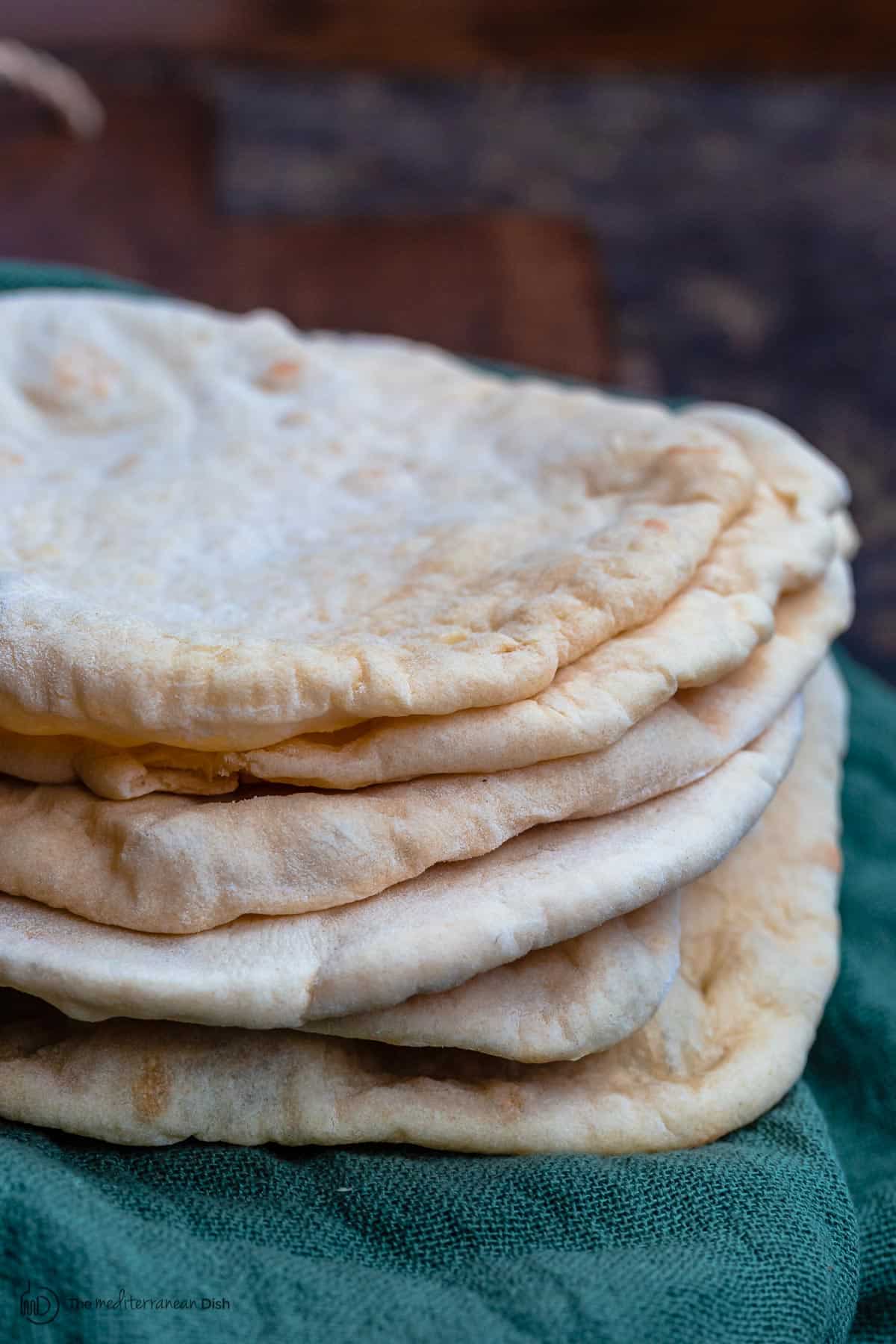 Stack of pita bread over a kitchen towel