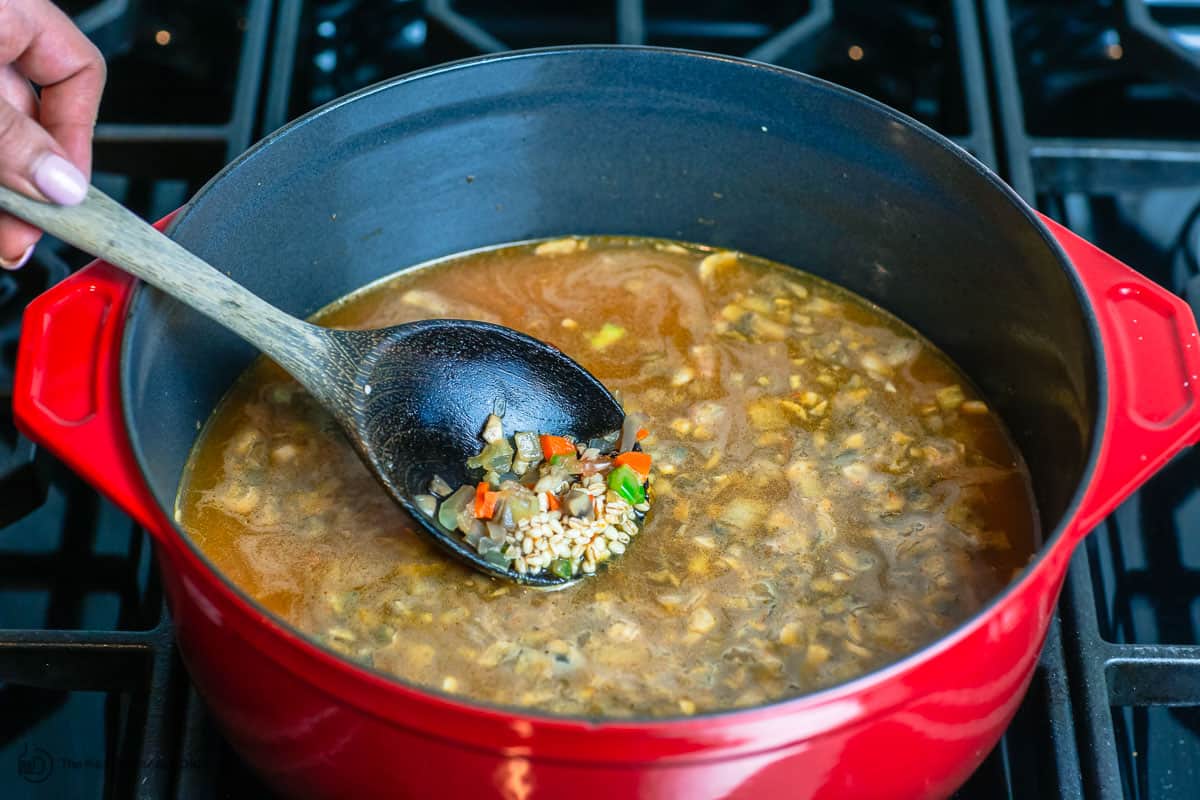 broth and barley are added to the pot