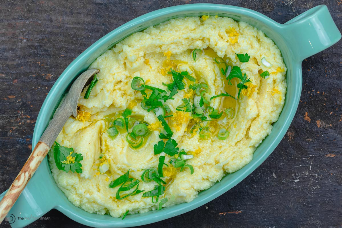 finished skordalia garlic dip with garnish of green onions, parsley and lemon zest