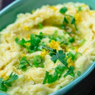 Skordalia greek garlic mashed potato dip in serving bowl with scallions and parsley for garnish