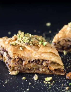 Two pieces of Greek baklava with pistachio pieces sprinkled on top