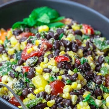 Black bean and corn salad with mint garnish. limes to the side