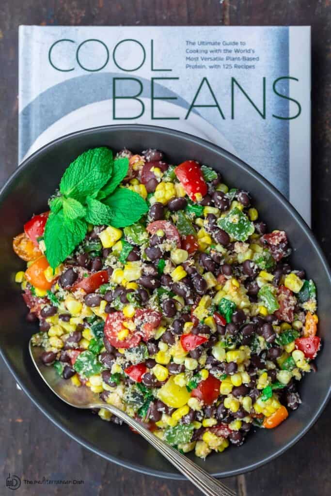 Bean salad in a serving platter placed on cookbook