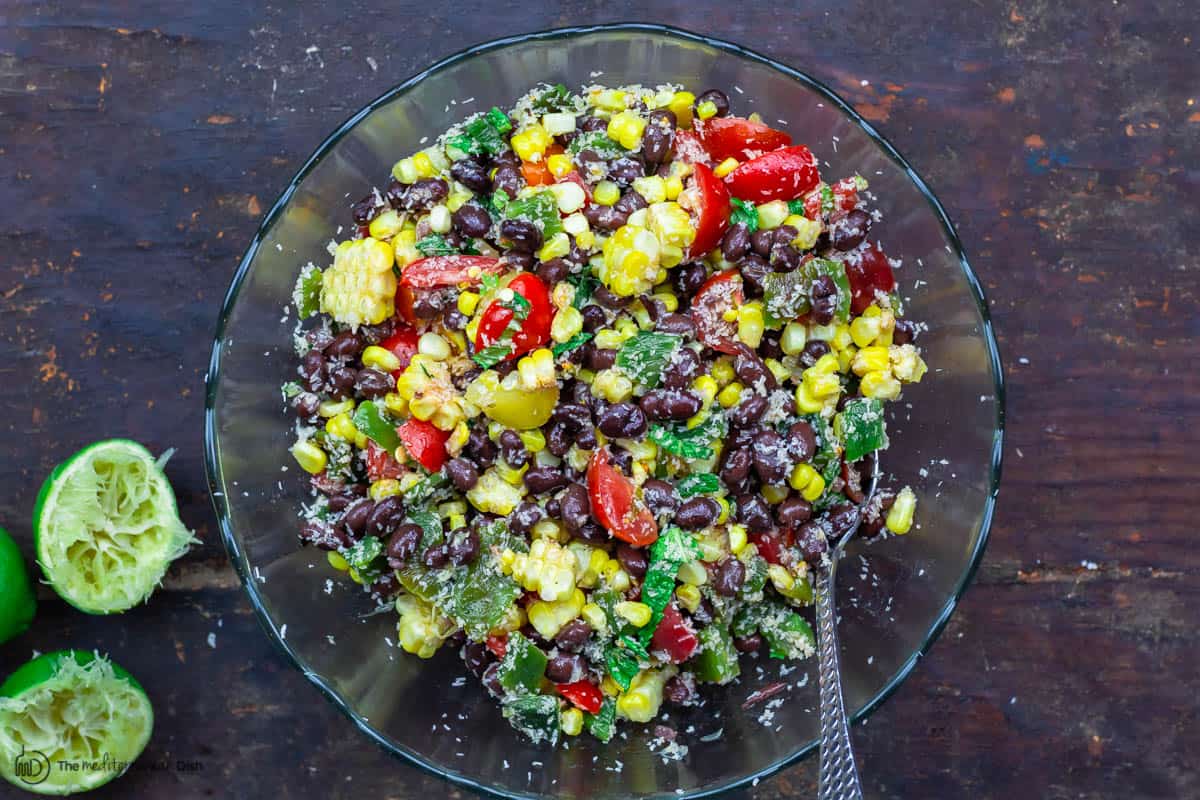 black bean and corn salad in a bowl. limes to the side