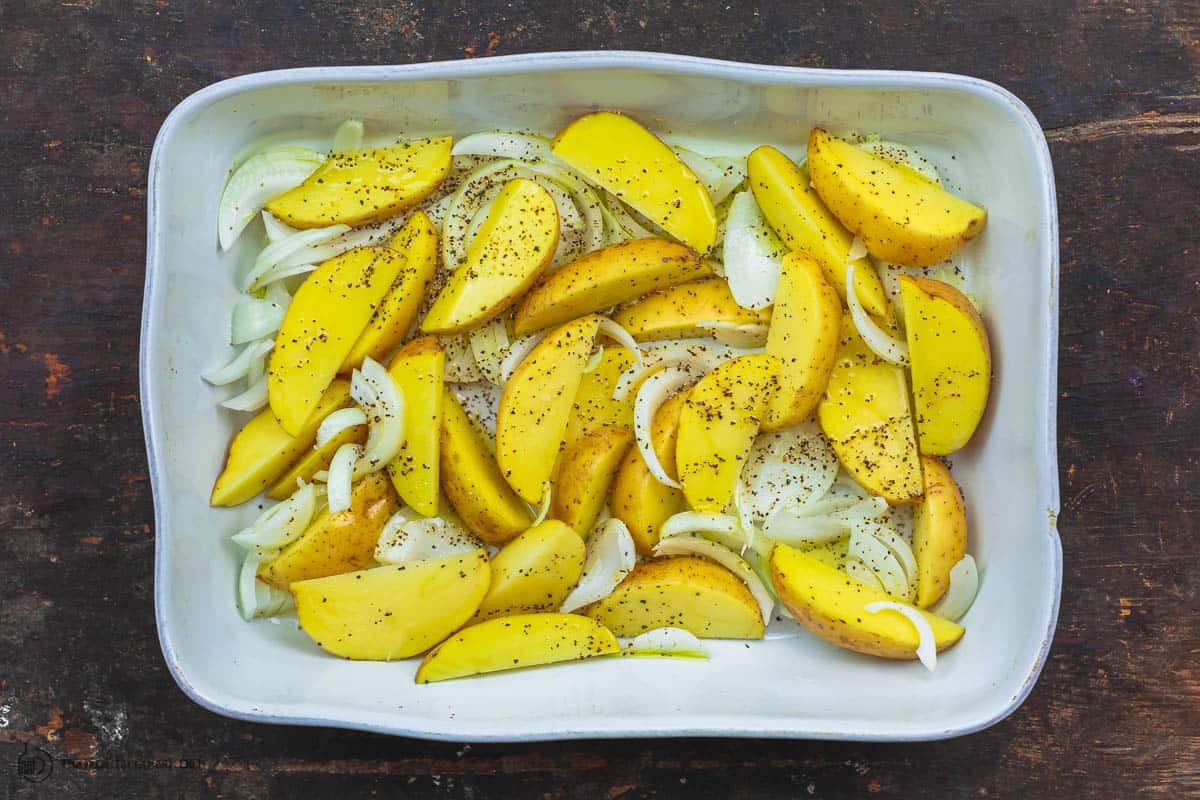 Potatoes and onions arranged in baking dish