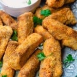 homemade fish sticks served with sauce and a sprinkle of fresh parsley