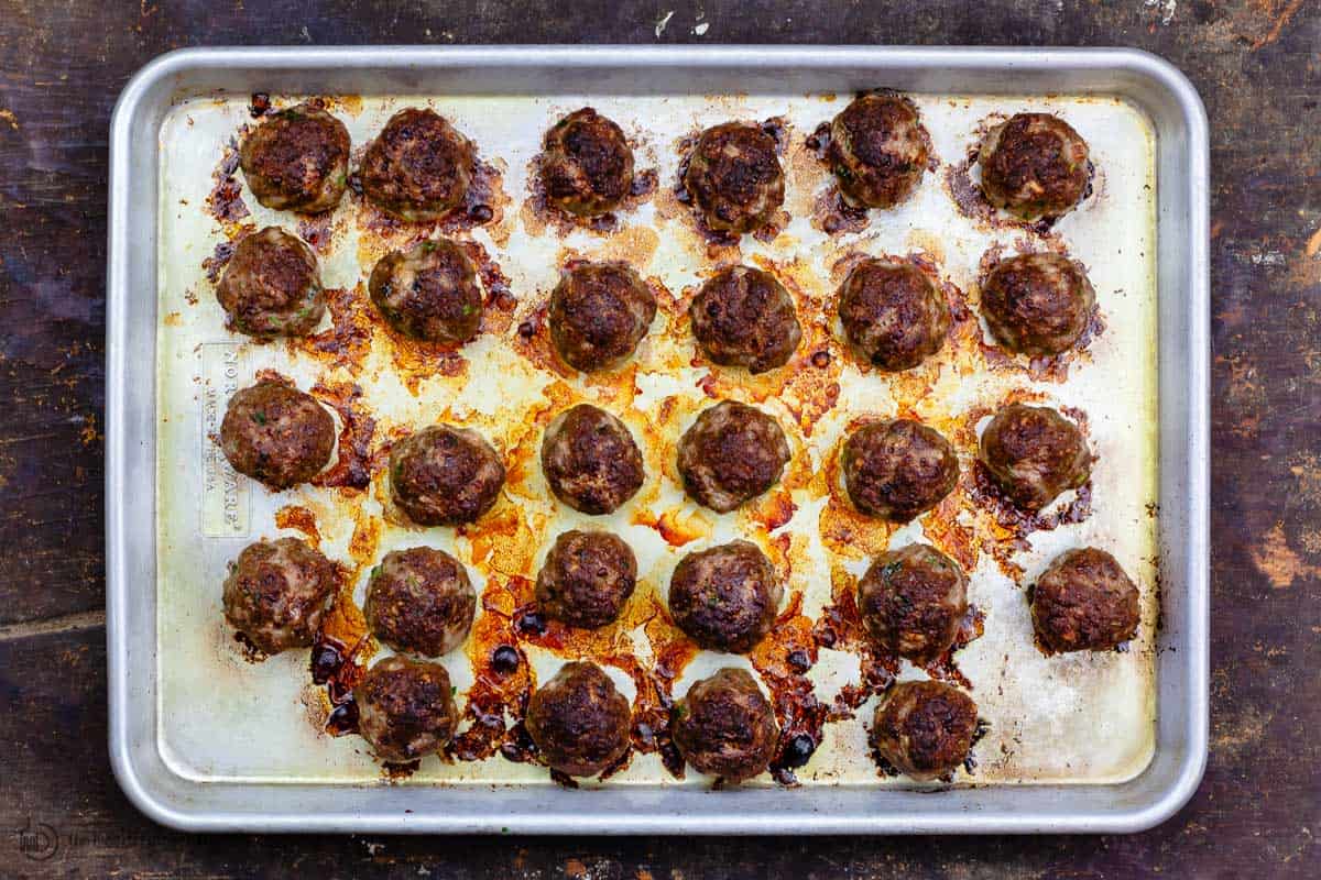 Broiled meatballs on a baking sheet