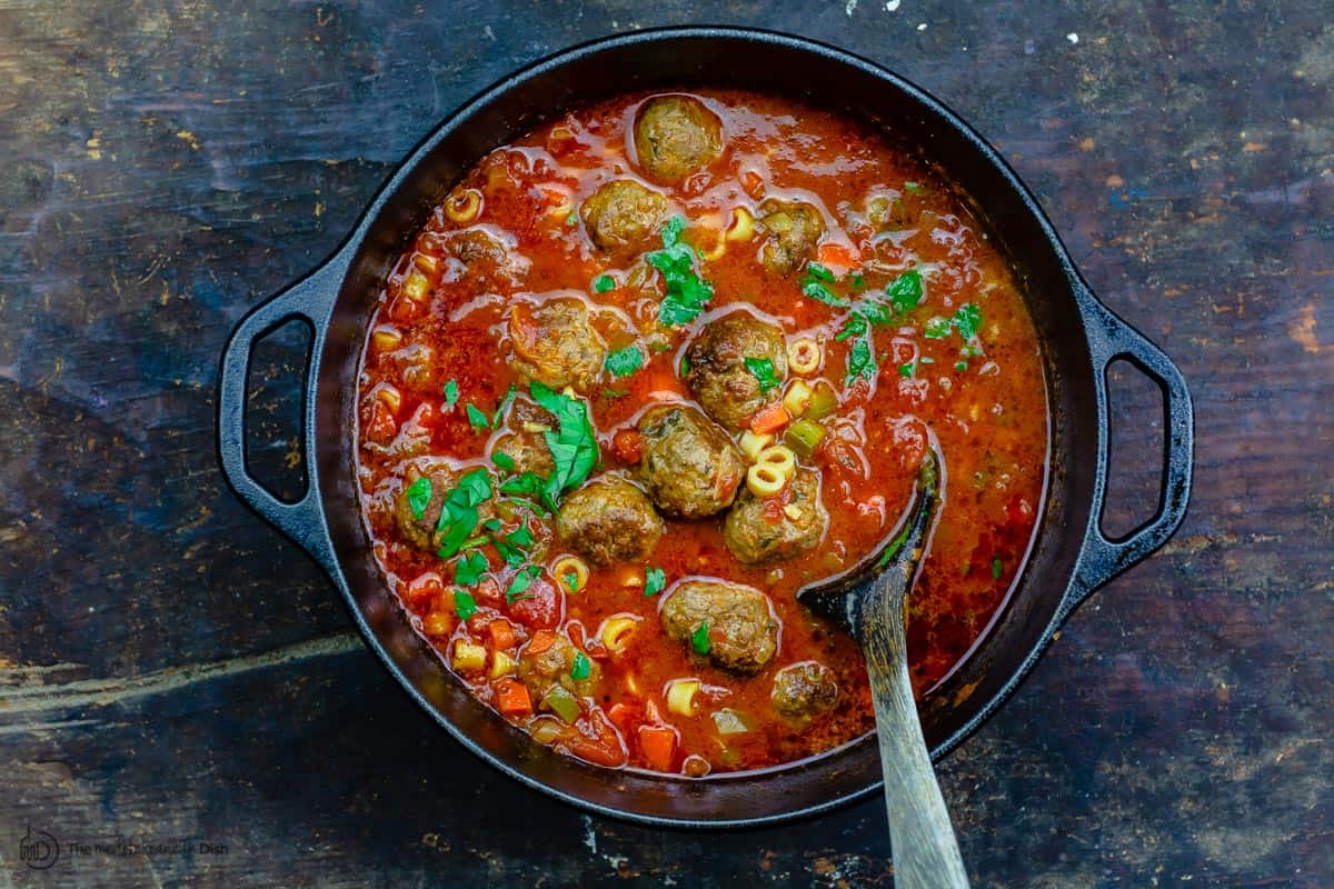 Meatball soup served in a large pot. Serving spoon in the pot