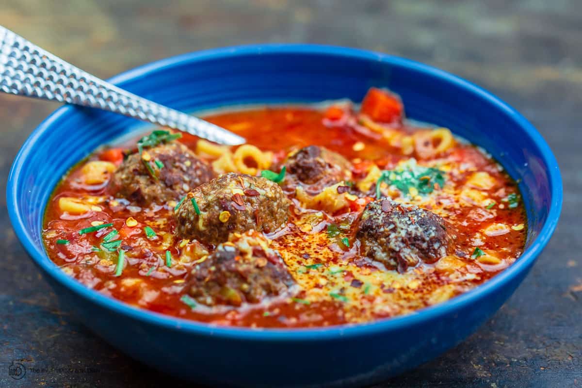 hot meatball soup served in a bowl with Parmesan cheese