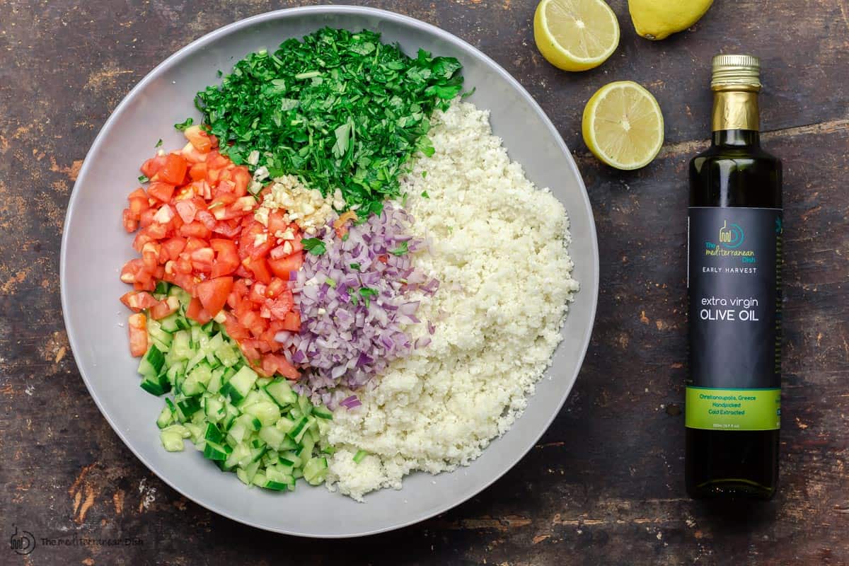 parsley, cucumbers, tomatoes and red peppers added to cauliflower rice to make salad