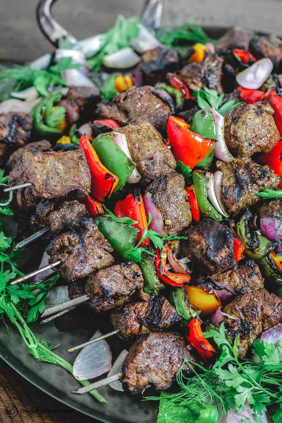 Steak kabobs with bell peppers and onions served on platter