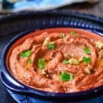 Muhammara in a bowl with a side of pita bread