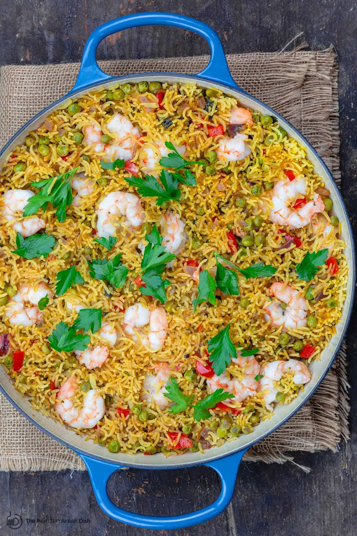 shrimp and rice in a blue pan. Garnished with parsley