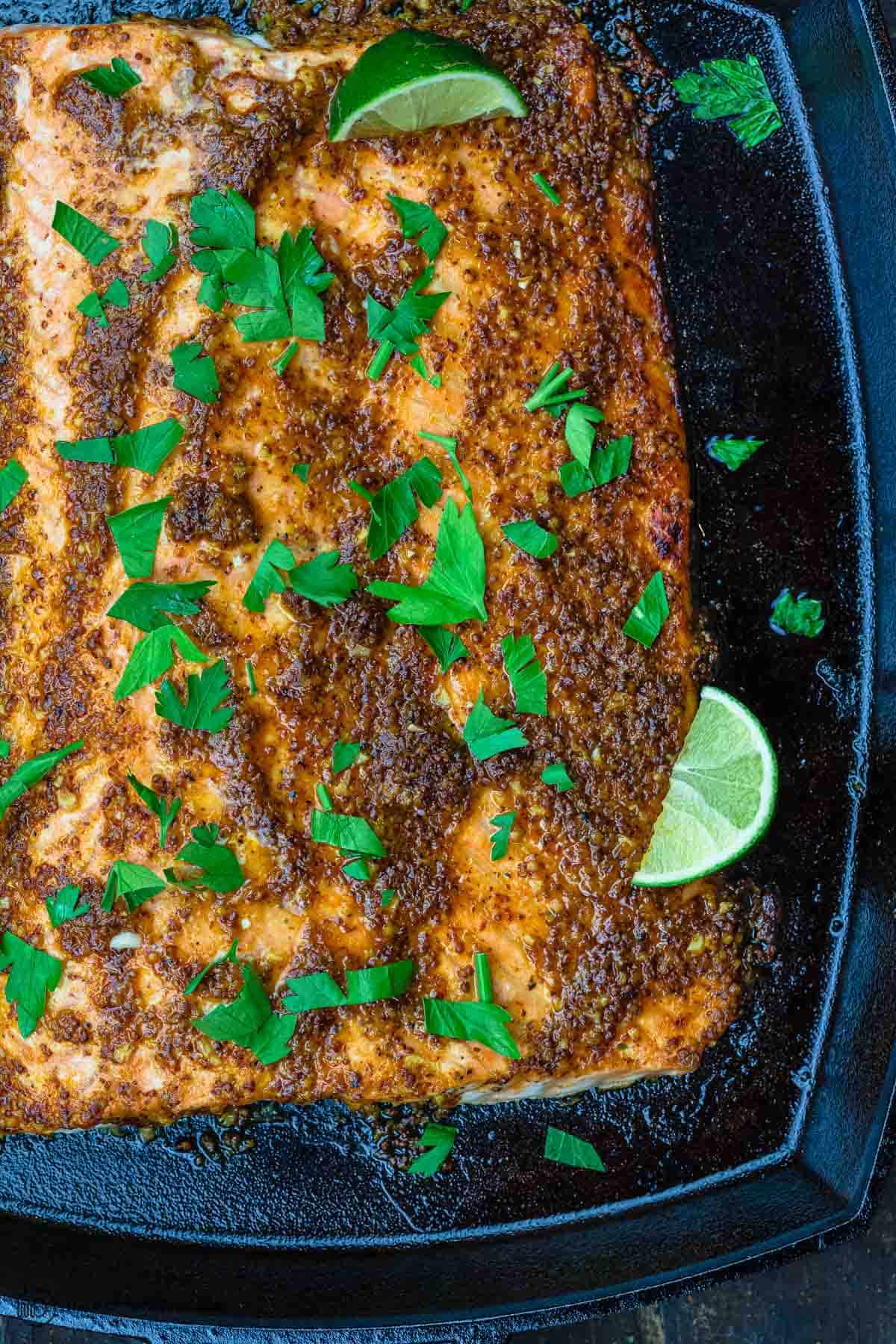 honey mustard salmon garnished with parsley and sliced lime