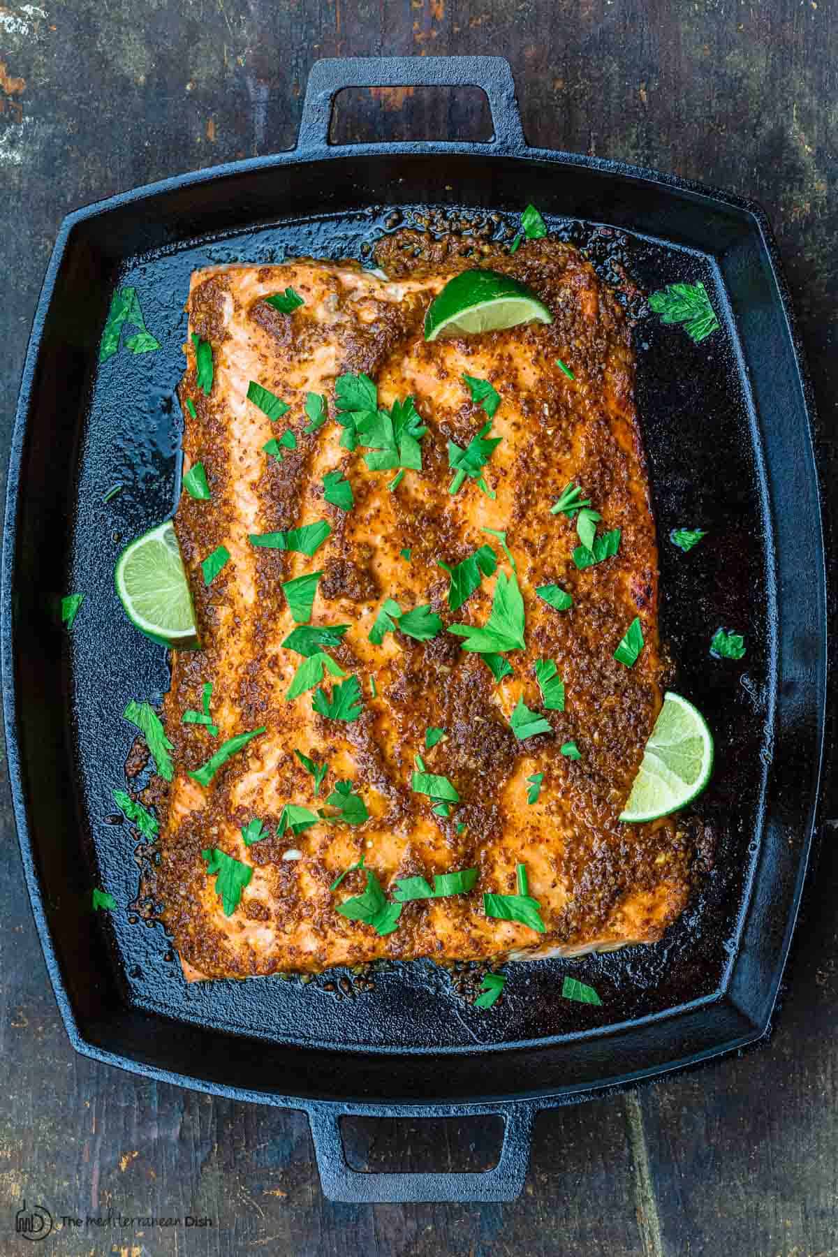 honey mustard salmon recipe in pan with lime wedges