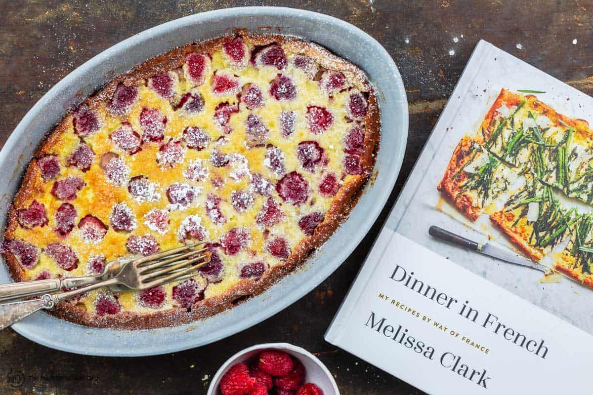 clafoutis next to a copy of Melissa Clark's book Dinner in French