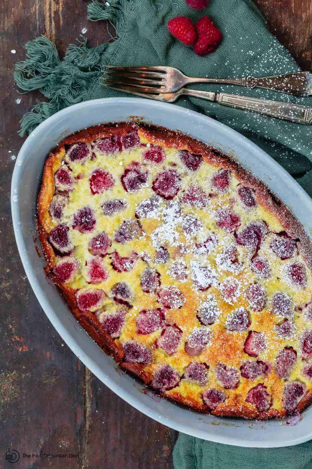 raspberry clafoutis in dish. Forks to the side for serving