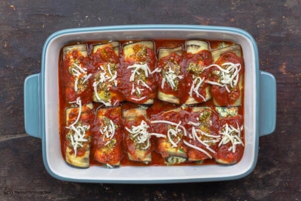 eggplant roll ups topped with sauce and mozzarella cheese