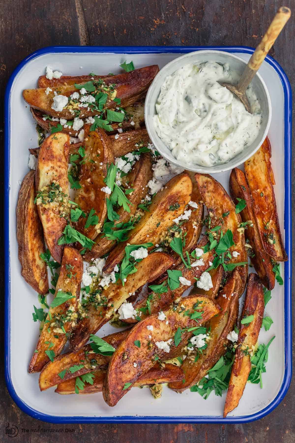 Oven fries with feta cheese and a side of tzatziki sauce