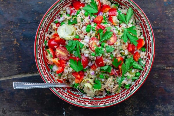 Rice salad served in a large red bowl