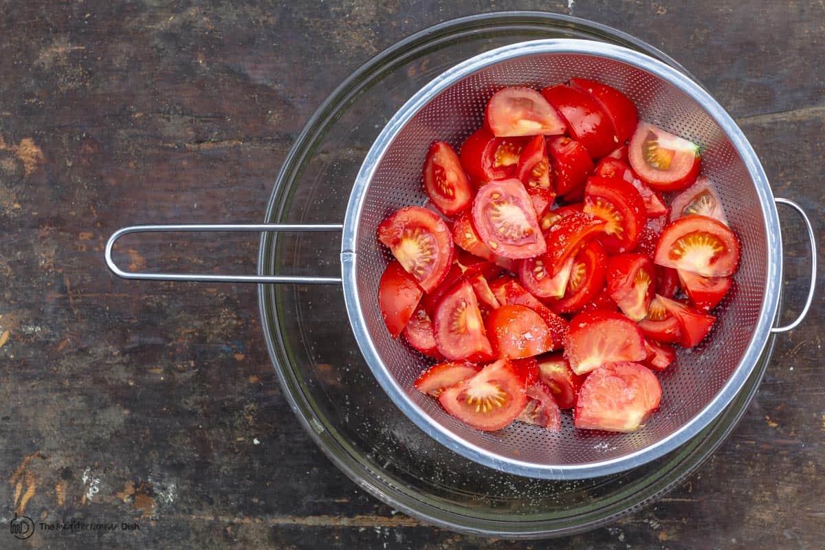 salted tomatoes in a colander