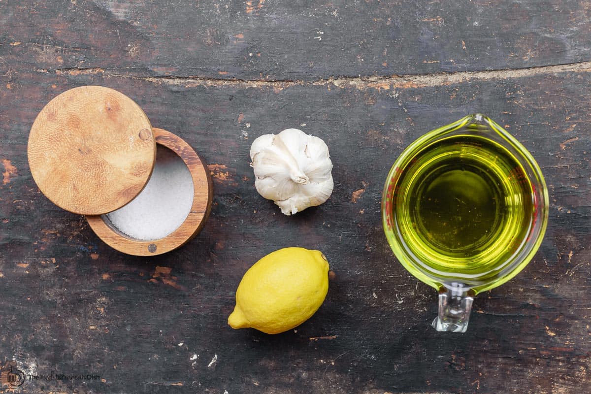 ingredients for toum recipe: garlic, lemon, oil, and salt