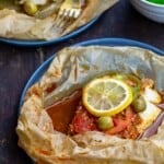 fish en papillote served on plates with side salad