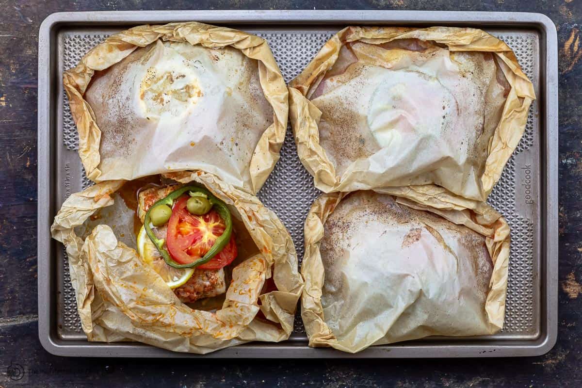 cooked fish en papillote on a baking sheet