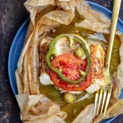 fish en papillote topped with green peppers and tomatoes