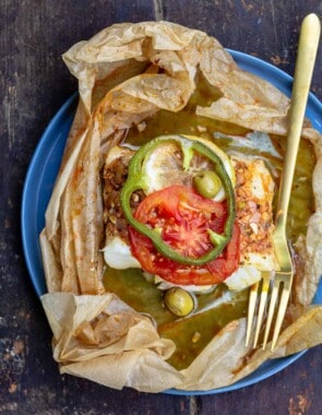 fish en papillote topped with green peppers and tomatoes