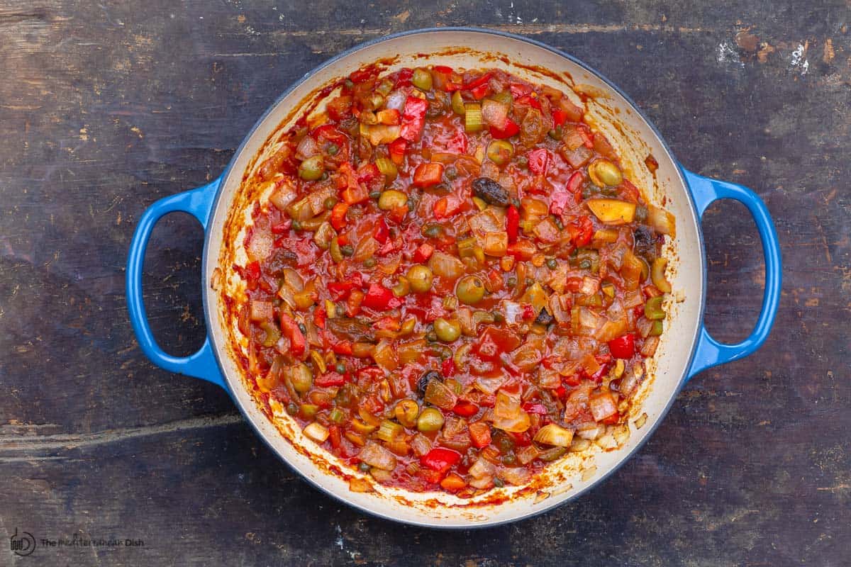 tomato sauce, olives and the remaining ingredients are added to the pan 