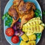 grilled whole chicken with a side of grilled vegetables
