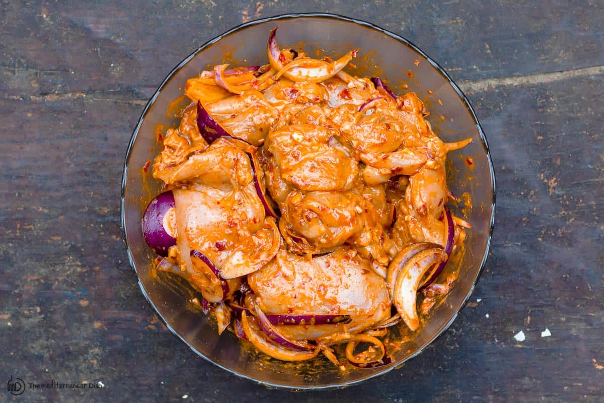 chicken thighs tossed in harissa paste, spices, garlic, and onions