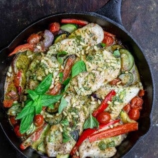 pesto chicken and vegetables in a pan