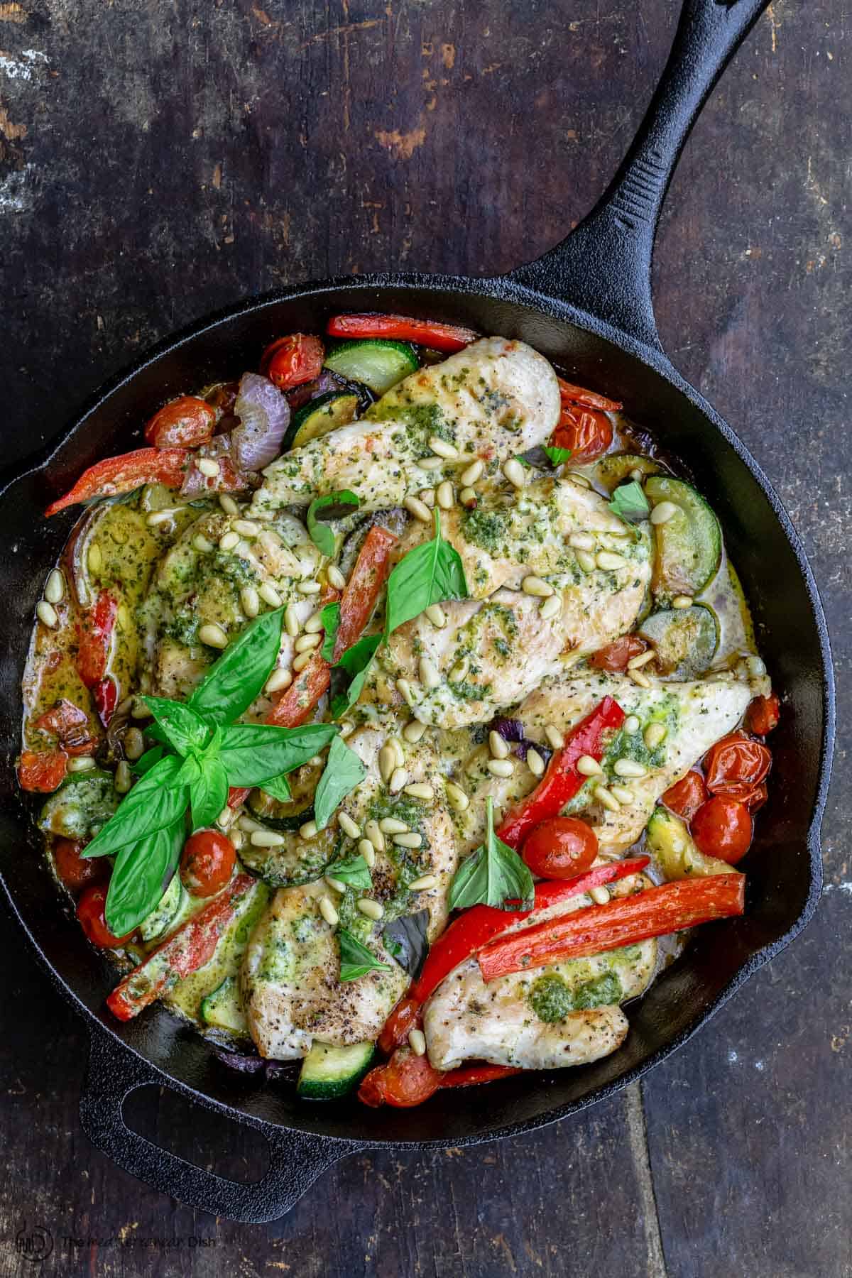 pesto chicken and vegetables in a pan