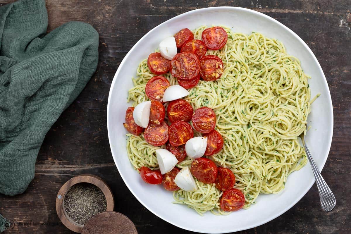 Pesto pasta in a large bowl with roasted tomatoes and mozzarella 